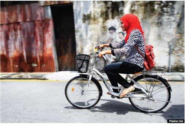 Penang girl on bike - covered head